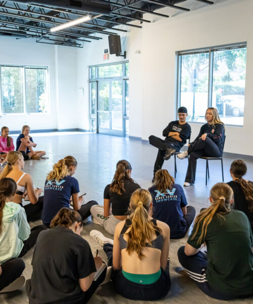 Competitive Competitive dancers sitting on the floor listening to their dance teachers at Evolution Dance Center in Carlsbad, CA