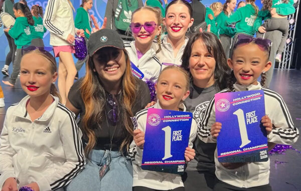 Lisa Esposito owner of Evolution Dance Center in Carlsbad posing with kids and teacher after a dance performance.